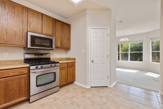 14204 Auberry, Helotes, TX 78023 - kitchen featuring stainless steel appliances, brown cabinetry, and a chandelier