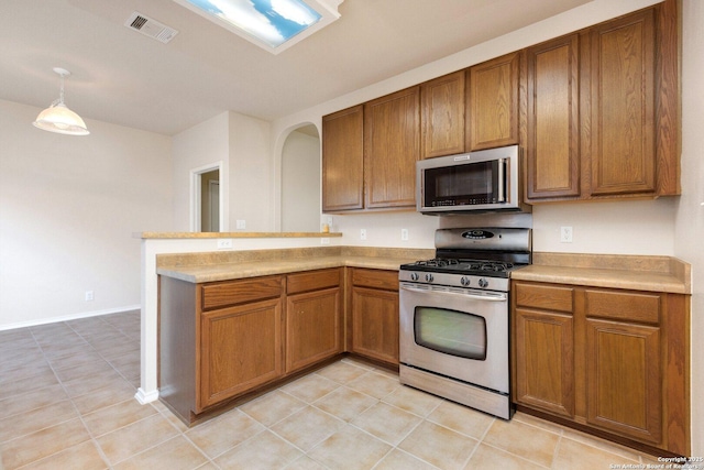 14204 Auberry, Helotes, TX 78023 - kitchen with appliances with stainless steel finishes, brown cabinets, a peninsula, light countertops, and light tile patterned floors