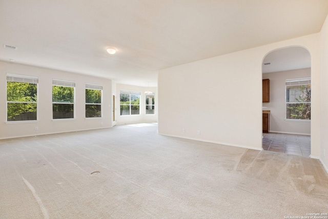 14204 Auberry, Helotes, TX 78023 - unfurnished living room featuring light carpet, baseboards, and arched walkways