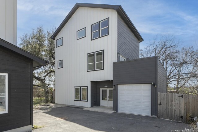 106 Bank St Unit 201, San Antonio, TX 78204 - rear view of house with aphalt driveway, an attached garage, french doors, and fence