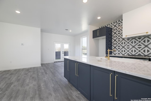 106 Bank St Unit 201, San Antonio, TX 78204 - kitchen featuring blue cabinetry, baseboards, recessed lighting, french doors, and wood finished floors