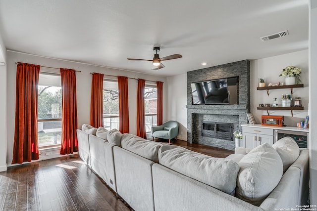 15110 Grayoak Frst, San Antonio, TX 78248 - living area with visible vents, dark wood finished floors, wine cooler, a fireplace, and ceiling fan