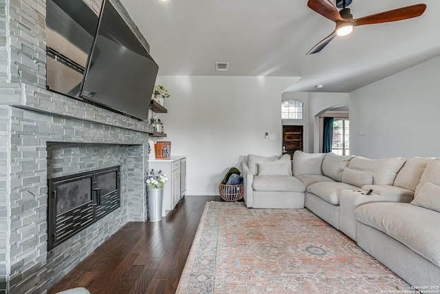 15110 Grayoak Frst, San Antonio, TX 78248 - living area featuring visible vents, dark wood-type flooring, a fireplace, arched walkways, and a ceiling fan