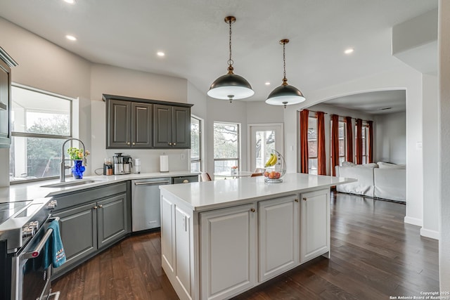 15110 Grayoak Frst, San Antonio, TX 78248 - kitchen featuring a kitchen island, arched walkways, a sink, stainless steel appliances, and light countertops