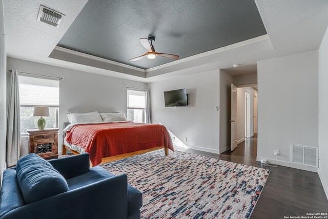 15110 Grayoak Frst, San Antonio, TX 78248 - bedroom with dark wood-style floors, visible vents, a raised ceiling, and baseboards