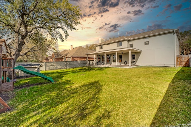 15110 Grayoak Frst, San Antonio, TX 78248 - back of house featuring a patio, a playground, a fenced backyard, and a lawn