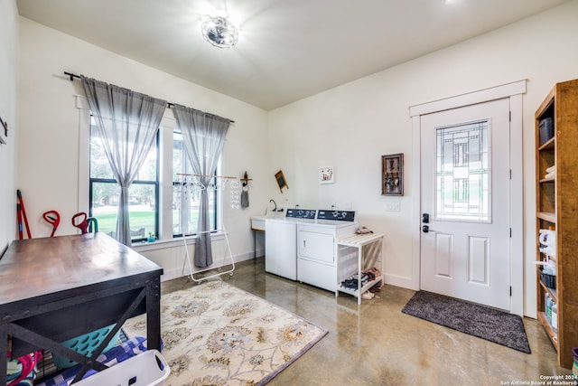 clothes washing area with washing machine and clothes dryer, laundry area, and baseboards