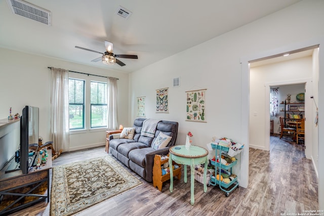 living area featuring visible vents, a ceiling fan, and wood finished floors