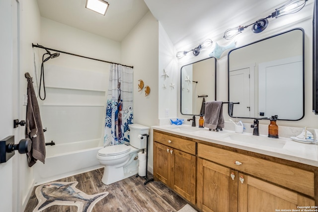 full bath with a sink, toilet, wood finished floors, and double vanity