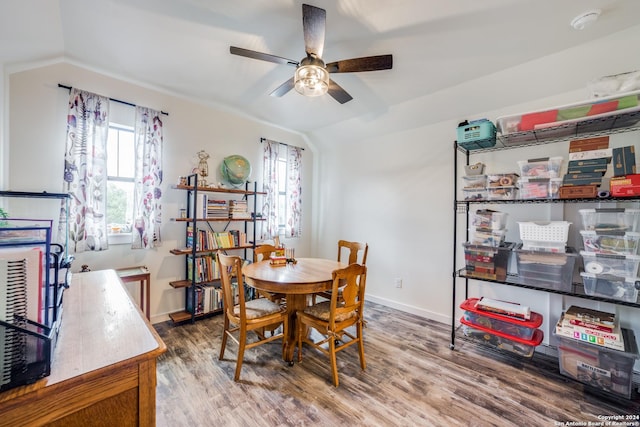 dining space with baseboards, wood finished floors, a ceiling fan, and vaulted ceiling