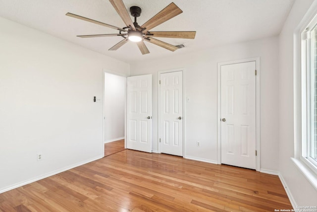 unfurnished bedroom with light wood finished floors, visible vents, and baseboards