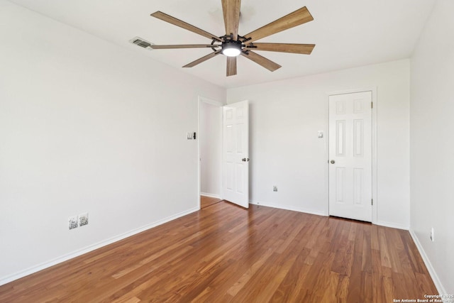 unfurnished bedroom with ceiling fan, visible vents, baseboards, and wood finished floors