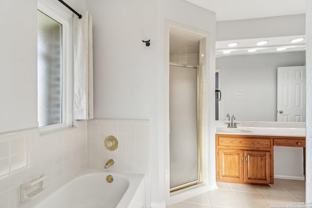 bathroom featuring tile patterned flooring, a shower stall, vanity, and a garden tub