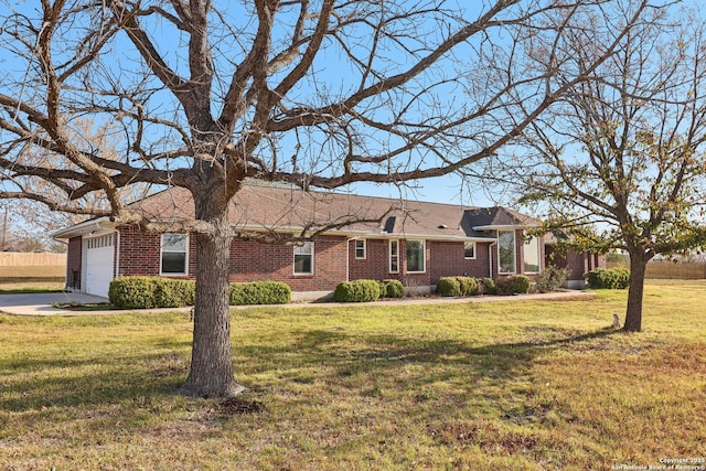 ranch-style house with a front yard, brick siding, and a garage