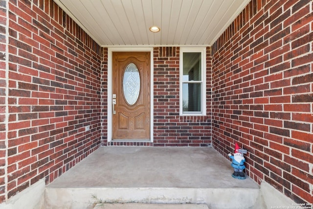 view of exterior entry featuring brick siding