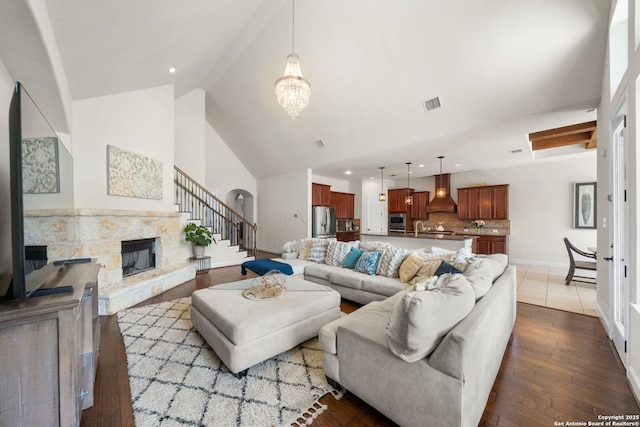 13606 Beck Ml, San Antonio, TX 78253 - living room featuring visible vents, dark wood finished floors, a stone fireplace, an inviting chandelier, and high vaulted ceiling