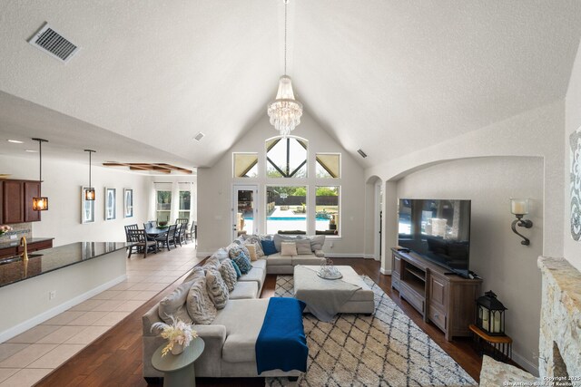 13606 Beck Ml, San Antonio, TX 78253 - tiled living area featuring visible vents, high vaulted ceiling, a sink, arched walkways, and a chandelier