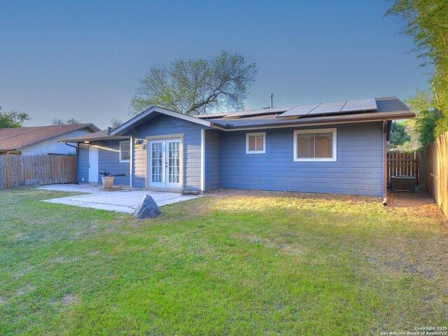 12226 La Barca, San Antonio, TX 78233 - back of property featuring french doors, a patio, roof mounted solar panels, and a fenced backyard