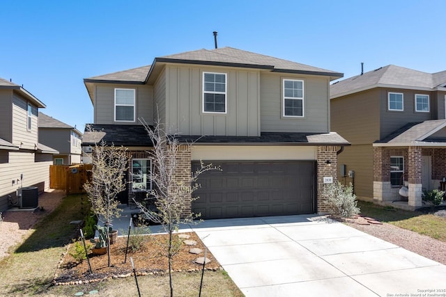 traditional home with board and batten siding, a shingled roof, concrete driveway, central AC, and an attached garage