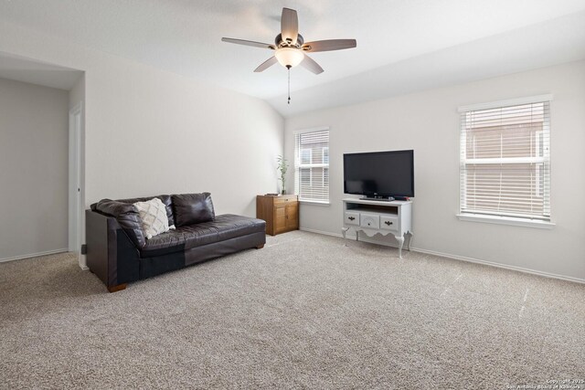 living area with baseboards, carpet floors, ceiling fan, and vaulted ceiling