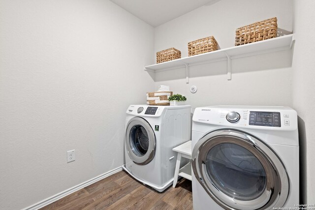 clothes washing area featuring baseboards, separate washer and dryer, wood finished floors, and laundry area