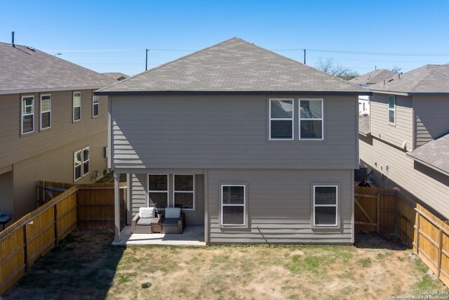 back of property featuring a patio, a yard, a fenced backyard, and a shingled roof