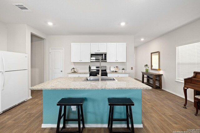 kitchen with visible vents, appliances with stainless steel finishes, dark wood-style flooring, and a sink