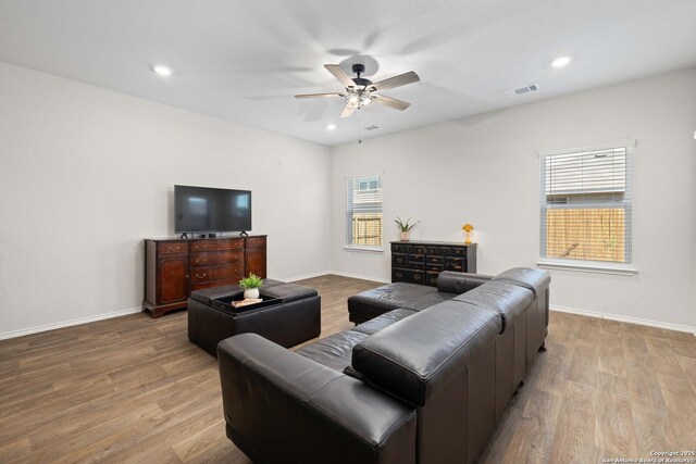 living room featuring visible vents, a ceiling fan, and wood finished floors