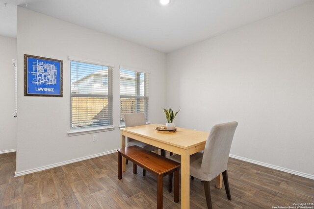 dining space with baseboards and wood finished floors