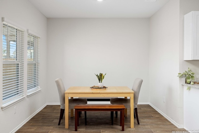 dining space featuring wood finished floors and baseboards