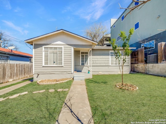view of front facade featuring a front yard and fence