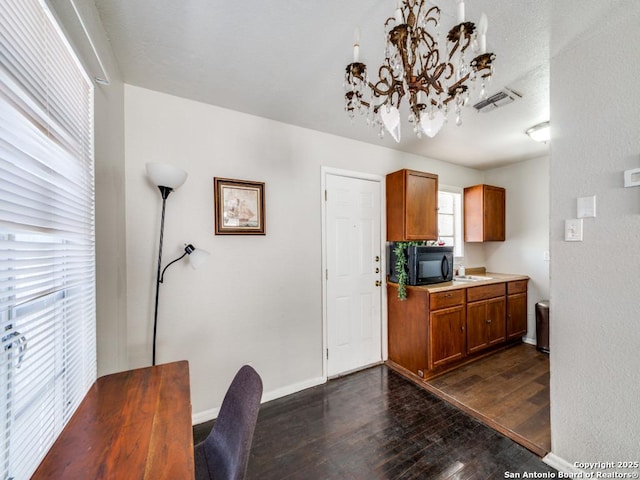dining room with an inviting chandelier, visible vents, dark wood-style flooring, and baseboards