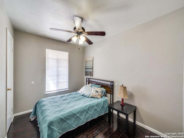 bedroom featuring ceiling fan, baseboards, and wood finished floors