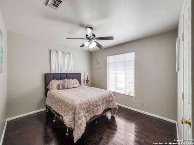 bedroom with a ceiling fan, hardwood / wood-style flooring, baseboards, and visible vents