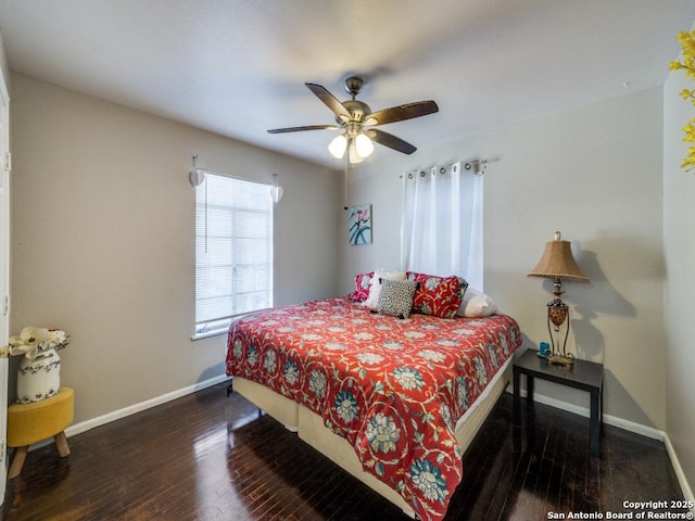 bedroom featuring baseboards, wood finished floors, and a ceiling fan