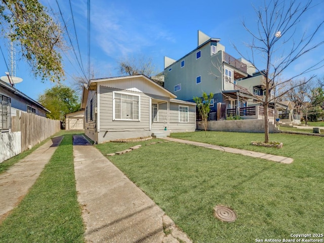 rear view of property with a yard, fence, and a garage