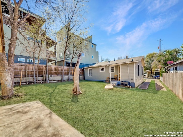 back of house with a patio, a yard, and a fenced backyard
