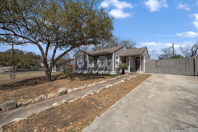 bungalow featuring a gate, concrete driveway, and fence