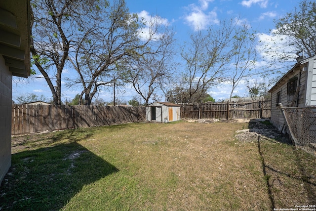 view of yard with a storage shed, a fenced backyard, and an outdoor structure
