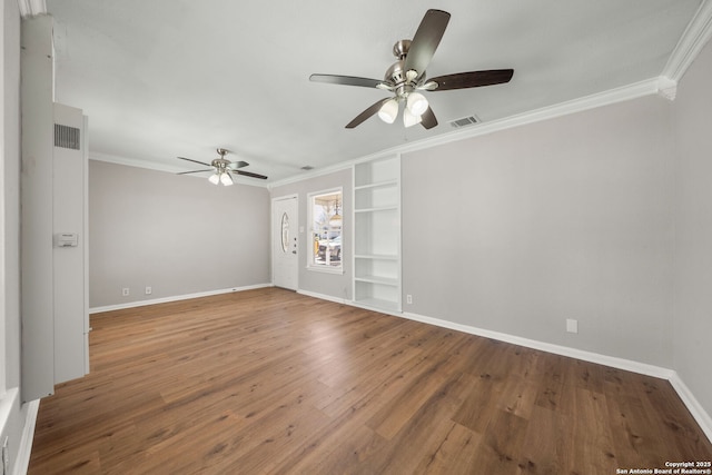 spare room featuring ornamental molding, wood finished floors, visible vents, and ceiling fan