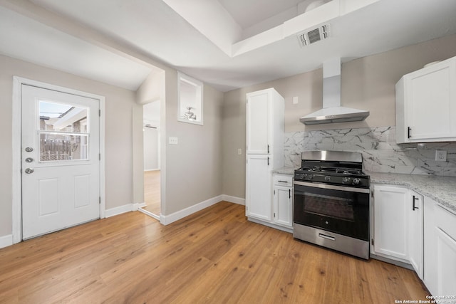kitchen with stainless steel gas range oven, visible vents, decorative backsplash, and wall chimney range hood