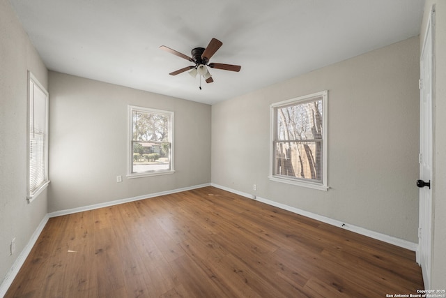 unfurnished room featuring baseboards, a ceiling fan, and hardwood / wood-style flooring