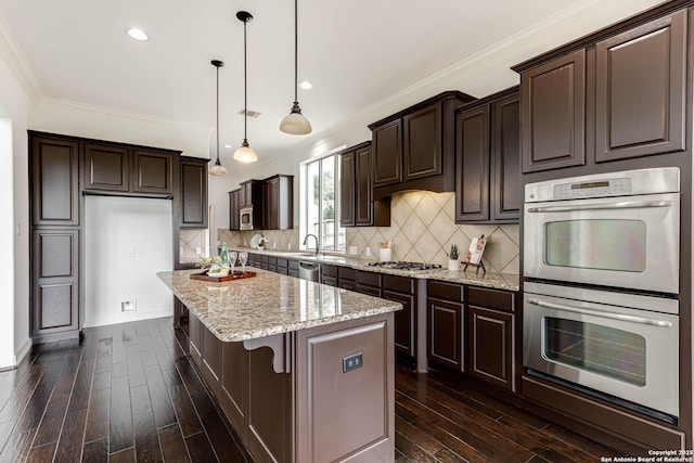 kitchen featuring dark wood finished floors, appliances with stainless steel finishes, dark brown cabinetry, and a kitchen island
