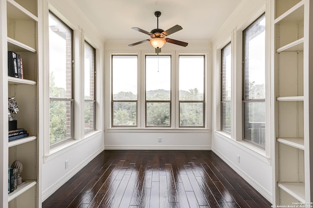 unfurnished sunroom featuring baseboards and hardwood / wood-style flooring