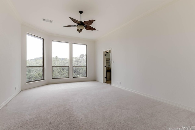 spare room with ornamental molding, light carpet, and visible vents