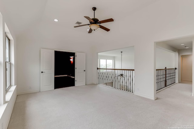 carpeted spare room with recessed lighting, ceiling fan, visible vents, and a towering ceiling