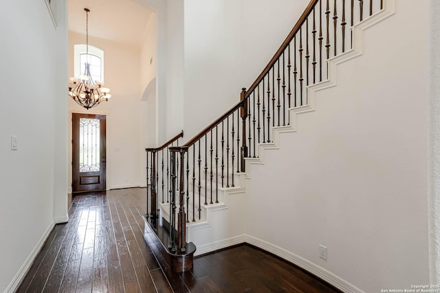 foyer entrance with an inviting chandelier, baseboards, dark wood-style floors, and a wealth of natural light