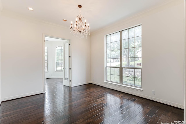 empty room with crown molding, dark wood-style flooring, baseboards, and a chandelier
