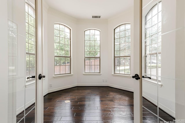 interior space featuring plenty of natural light, french doors, dark wood-style flooring, and visible vents