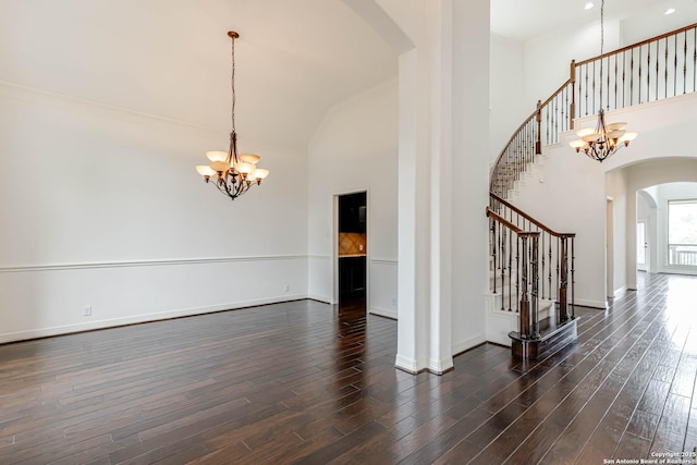 interior space with an inviting chandelier, arched walkways, baseboards, and stairway